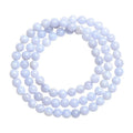 Close-up of a blue agate beaded bracelet with multi-circle pattern and scattered striped beads on a wrist.