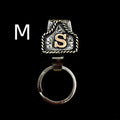 Handmade metal keychain shaped like a cow tag with a belt-style link for keys.