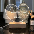 Custom engraved acrylic night light displaying personal names and a date, lit from a base LED.