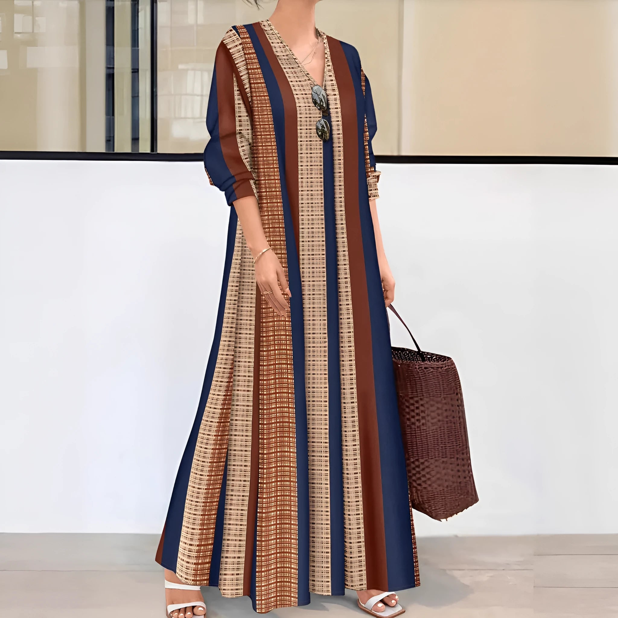 Camel coloured women's long dress with vertical stripes, a V-neck, and long sleeves on a mannequin.