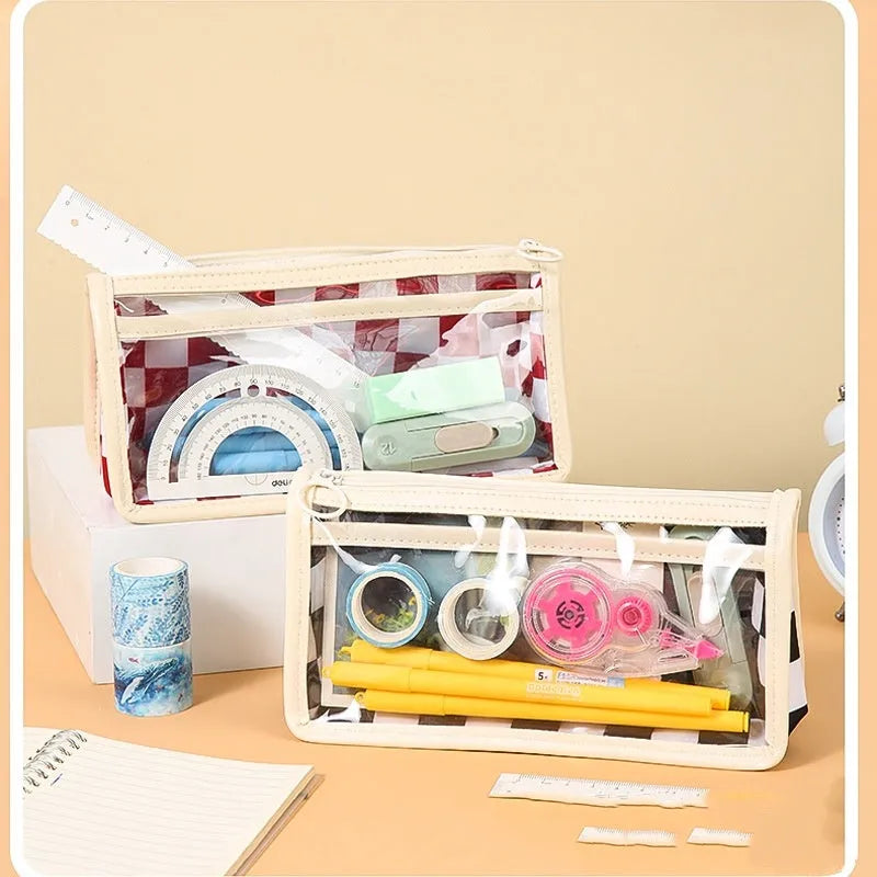 Large transparent PVC pencil case with a black and white chessboard grid pattern, showing pens inside.