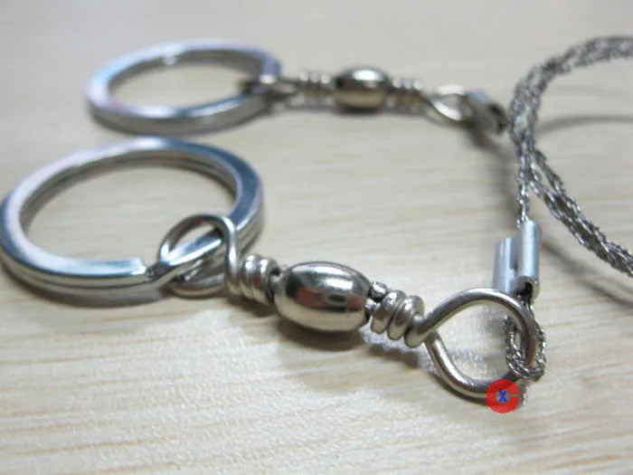 Stainless steel survival wire saw with pull rings, 55cm blade for outdoor wood cutting.