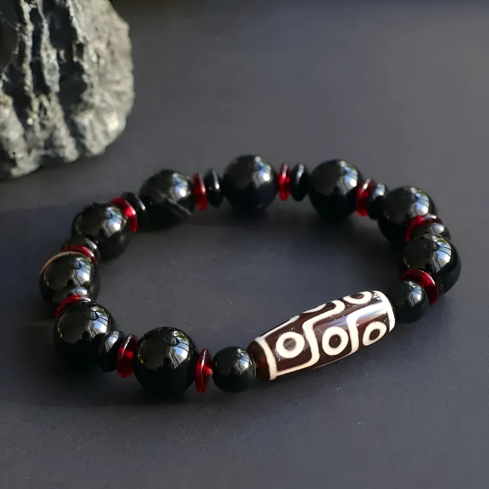 Black agate dzi bead bracelet with geometric beads and hand-woven construction