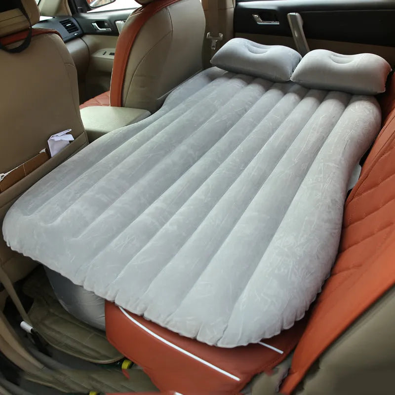 Black inflatable car bed with flocked surface, two pillows, and storage bag for five-seater vehicles
