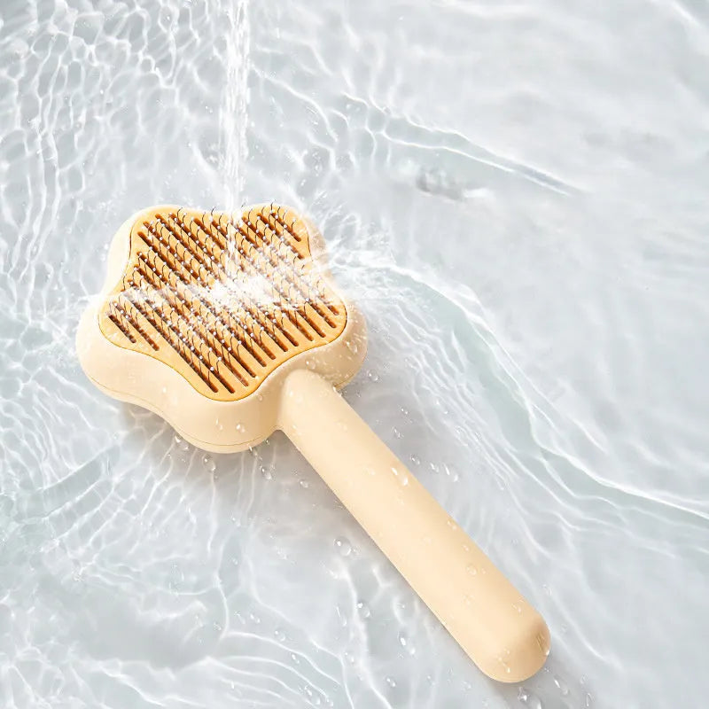 Green and yellow self-cleaning cat comb with stainless steel needles for pet grooming.