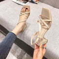 Women's white thick heel sandals with one-word strap and backless design on a rubber sole.