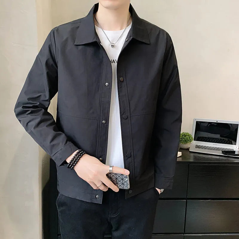 A man wearing a thin, single-layer Korean-style jacket in light grey, suitable for spring or autumn.