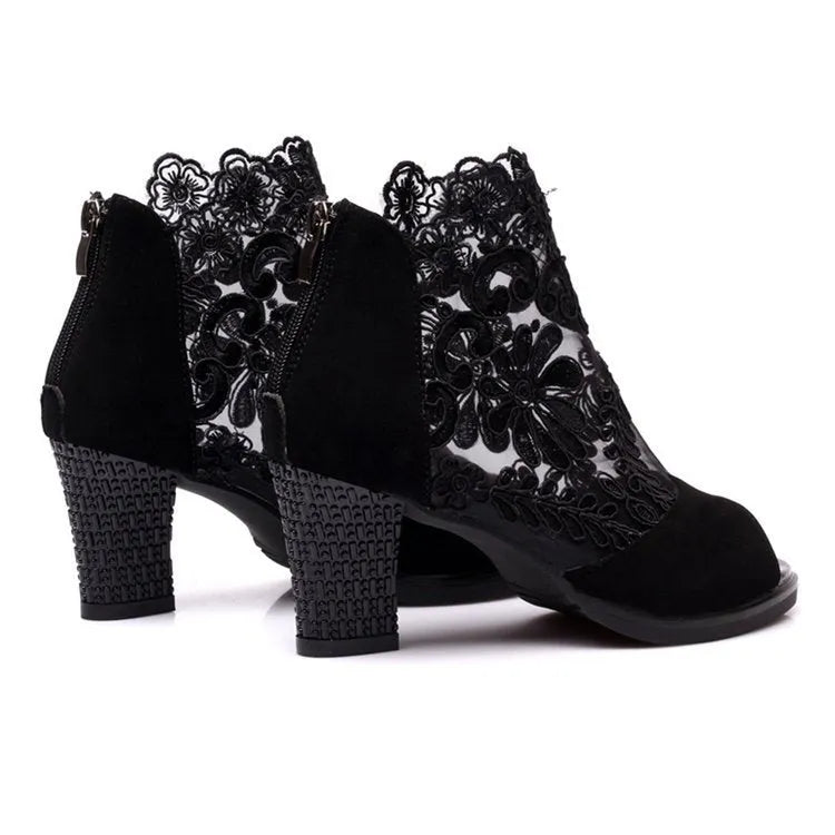 Women's black lace-up gladiator sandals with a square high heel and decorative floral detail on the peep toe