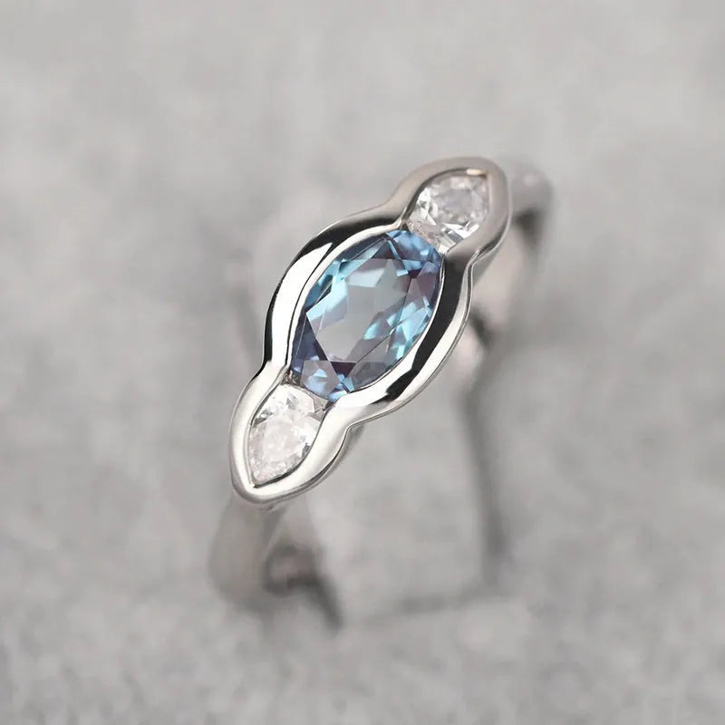 Geometric ellipse-shaped women's ring in white gold colour with inlaid zircon stones.
