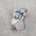 Geometric ellipse-shaped women's ring in white gold colour with inlaid zircon stones.
