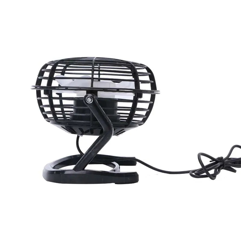 Small black USB desk fan with adjustable angle on wooden desk next to laptop