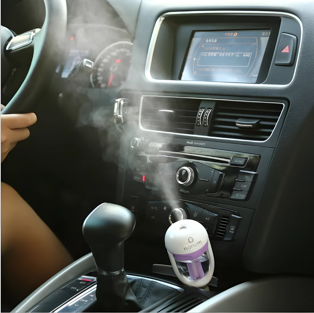 Compact blue car humidifier with rotation nozzle and essential oil diffusion capability on car dashboard