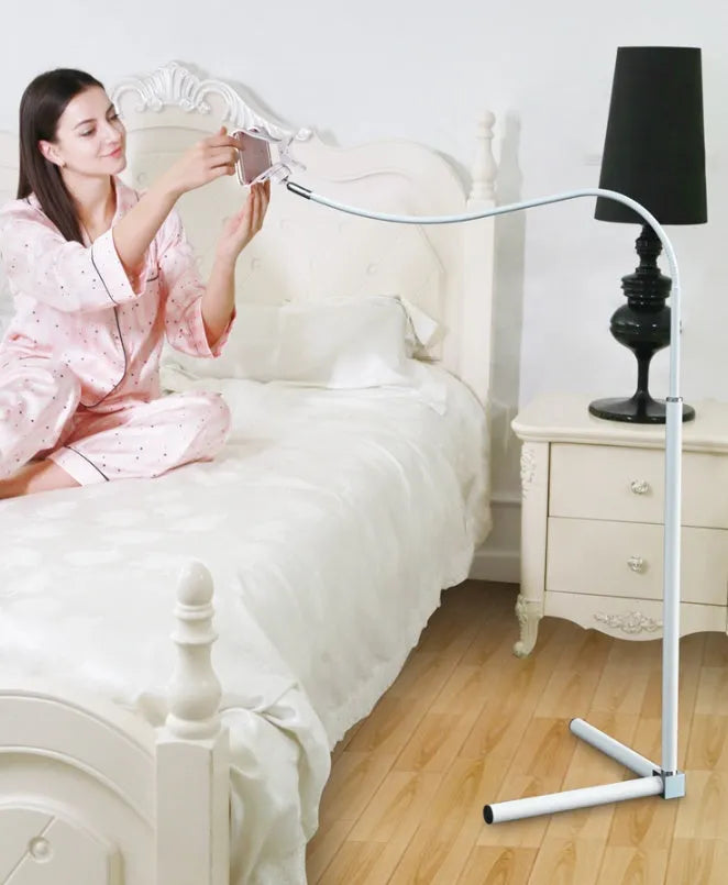 Black mobile phone bed bracket mounted beside bed frame holding smartphone