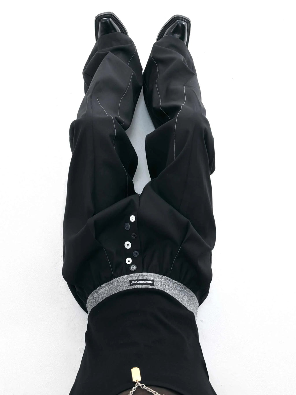Men's straight-leg casual trousers with drooping design and button detail in black or grey
