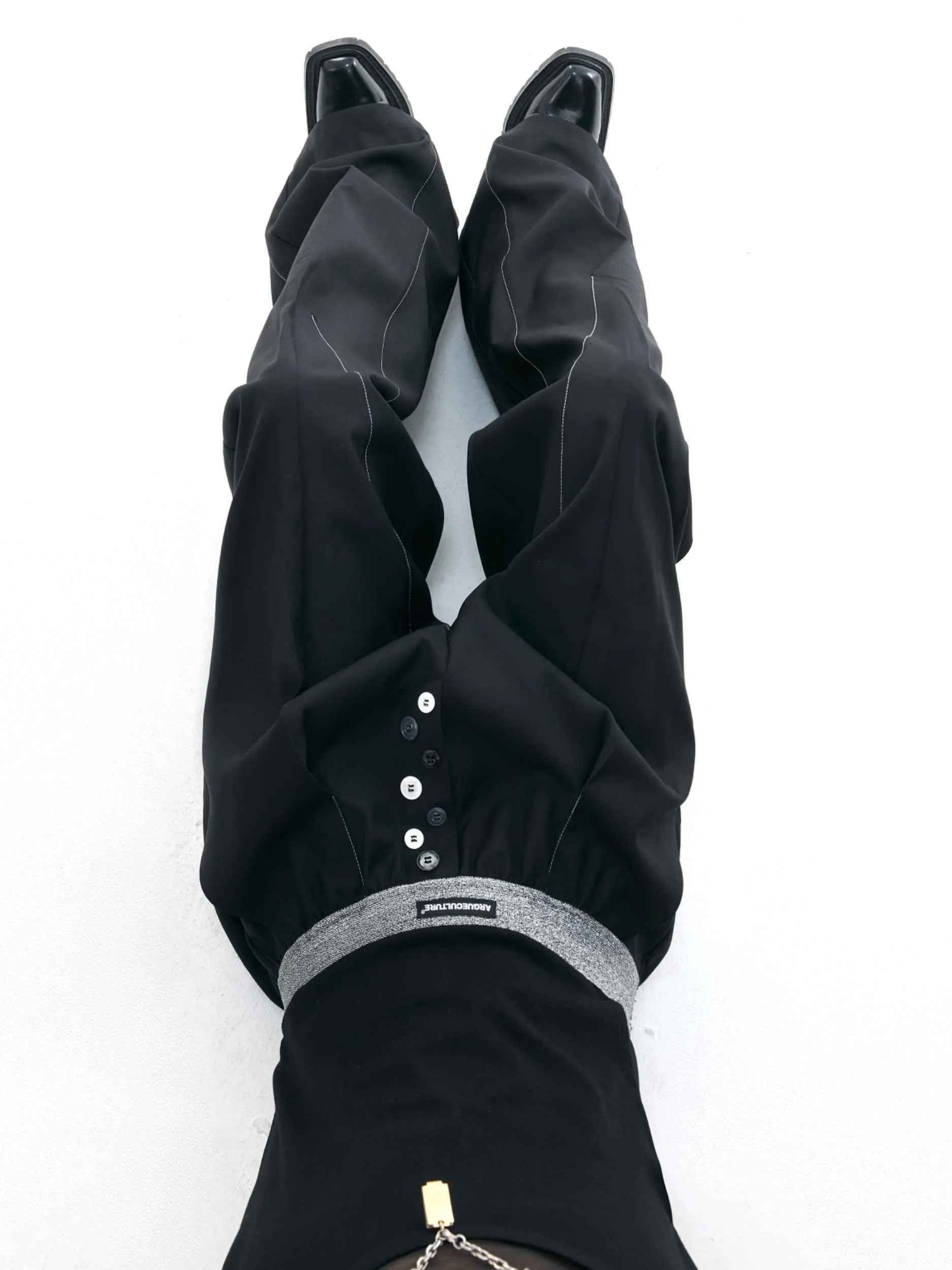 Men's straight-leg casual trousers with drooping design and button detail in black or grey