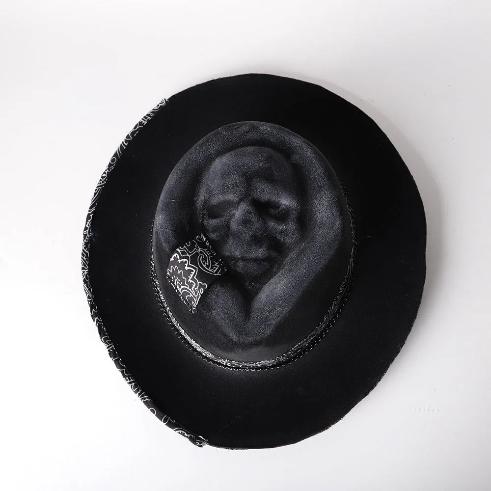 Handmade wool felt skull hat with a pointed conical crown on a neutral background