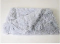 Dog blanket in long plush wool-polyester blend showing three size options and colour variations