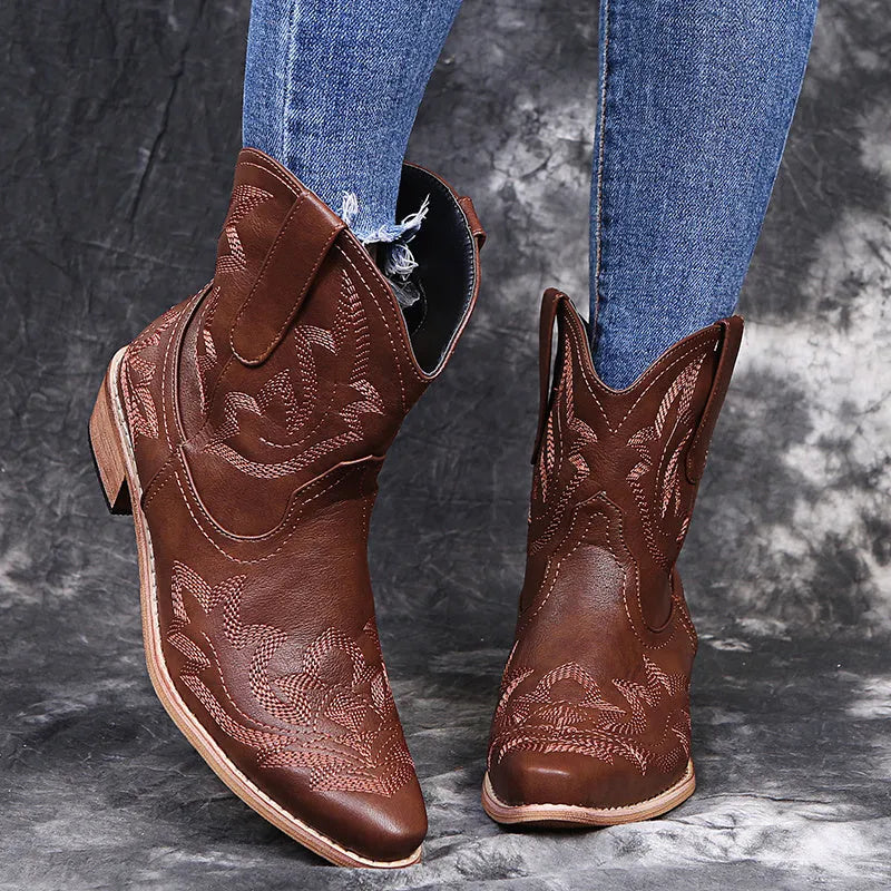 Blue women's cowboy boots with embroidered detail, a low wedge heel, and a pointed toe.