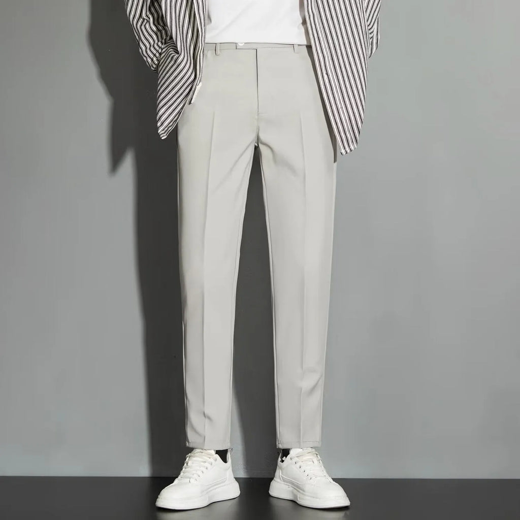 Man wearing apricot-coloured straight-leg suit trousers with an ankle-length draping effect.