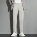 Man wearing apricot-coloured straight-leg suit trousers with an ankle-length draping effect.