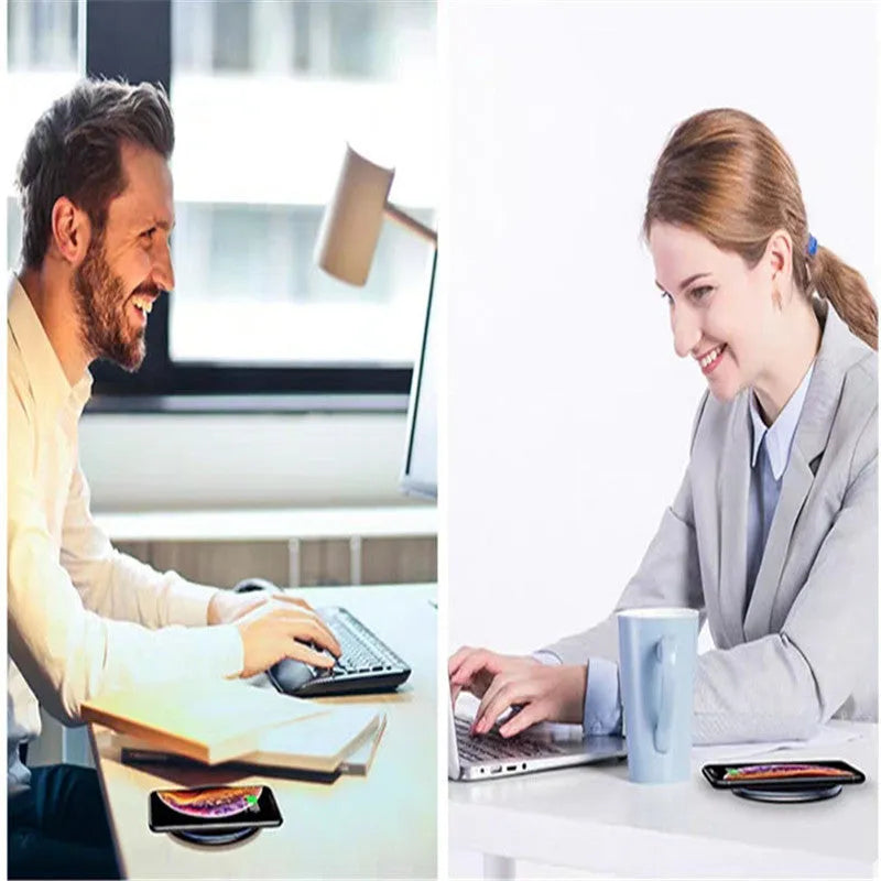 Black wireless charging pad on desk with phone charging, showing blue LED indicator light