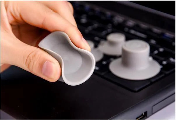 Grey plastic laptop cooling pads, two large and two small, placed under a mini notebook.