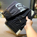Men's solid black ultra-thin ice silk cotton trousers with a cropped leg and elasticated ankle band.