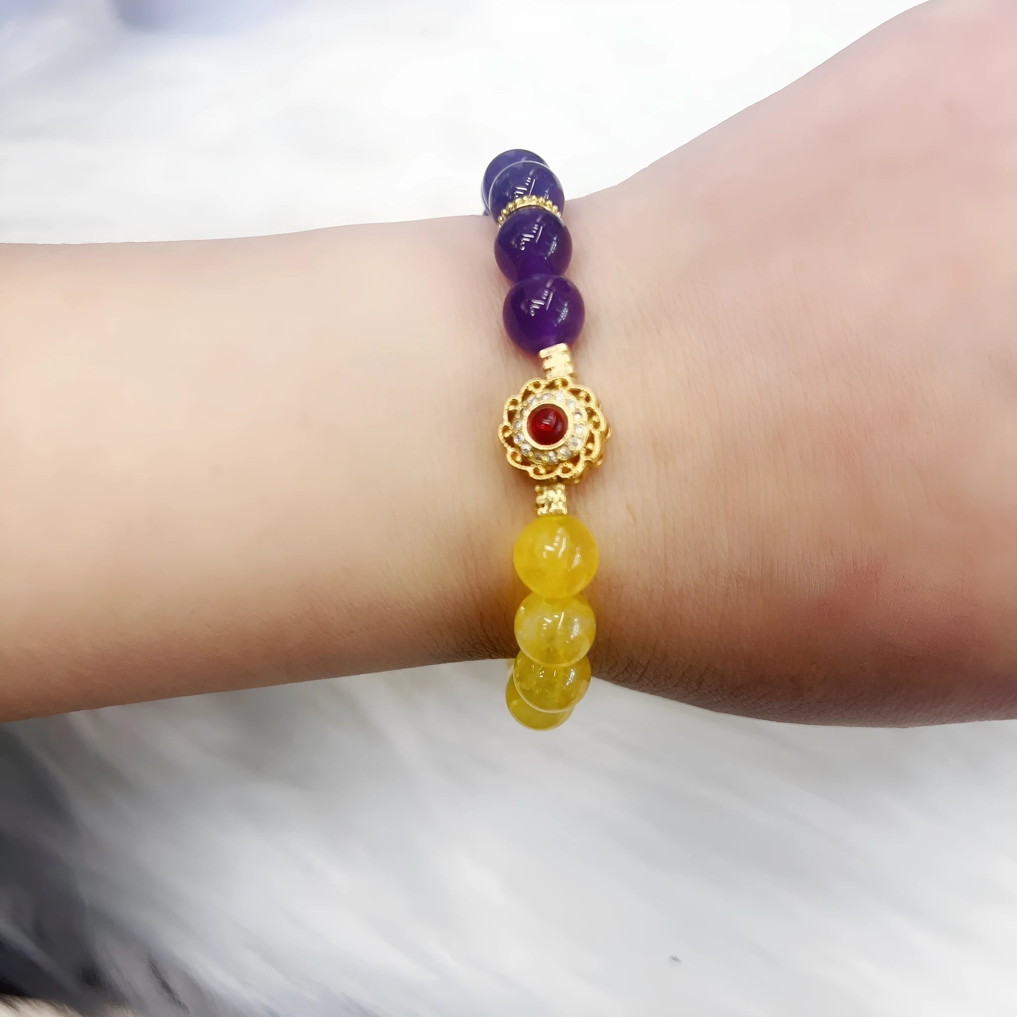 Handmade women's yellow and purple amethyst crystal bracelet showing manual craftsmanship details