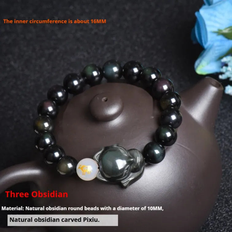 Natural black obsidian bracelet with 10mm beads on wrist, showing gold tone fastening option.