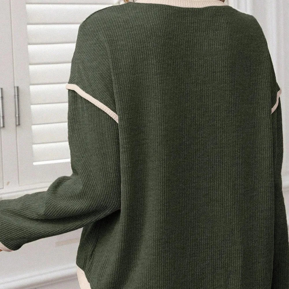 Loose fit beige knitted top with drop shoulders and contrast trim on a hanger.