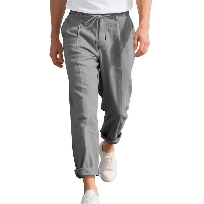 Man wearing light khaki straight-leg linen trousers with a drawstring waist.