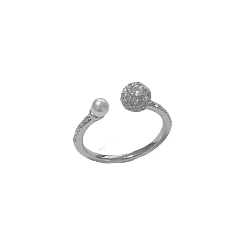 Golden round zircon open-end pearl ring with geometric shape on female hand