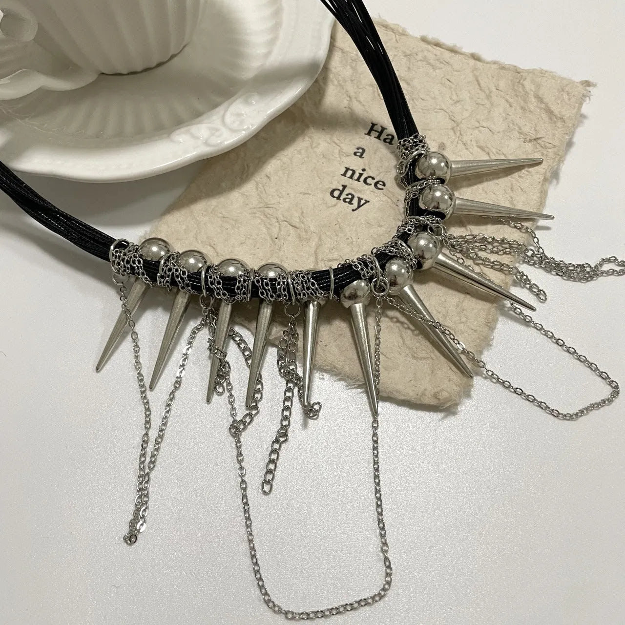 Women's casual leather necklace with electroplated round beads, a winding tassel, and point rivet details.