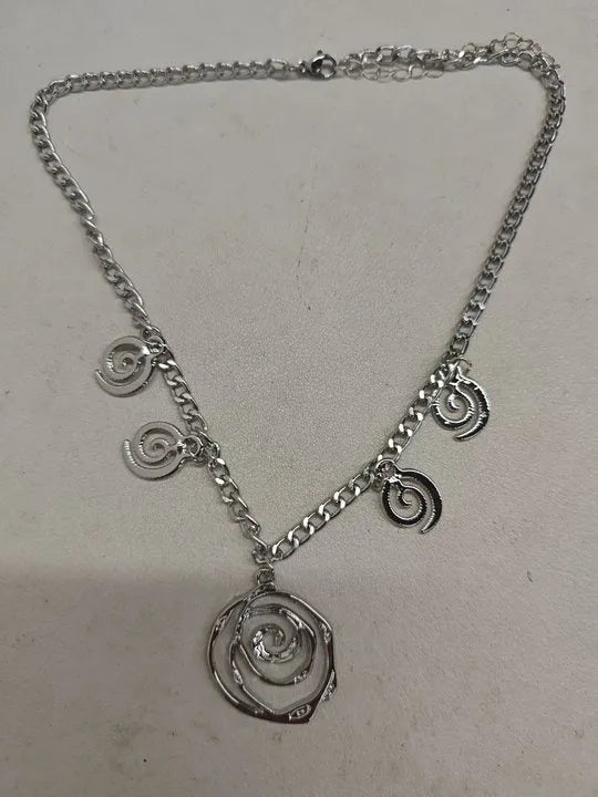 Gold spiral donut necklace, bracelet, and earrings set for women on a grey background.