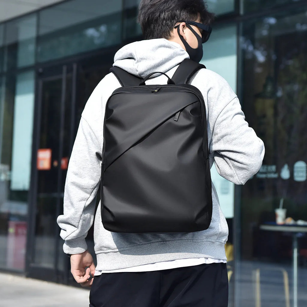 Large waterproof backpack in black with sewing thread detailing and included computer bag