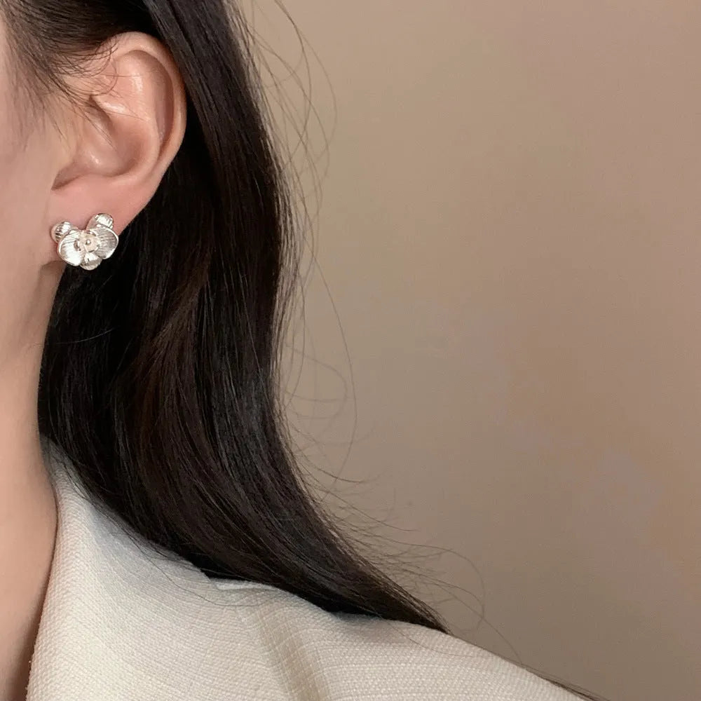 A pair of women's retro-style flower drop earrings with petal details in a gold or silver electroplated finish.