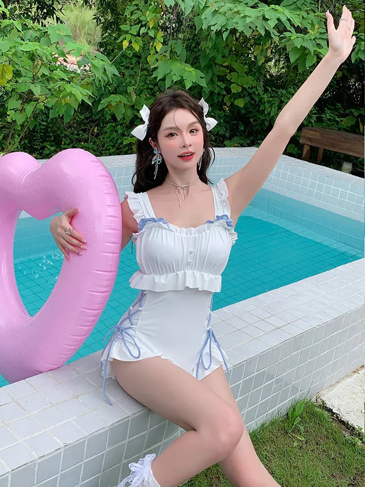 Milky white backless one-piece swimsuit for women on a hanger