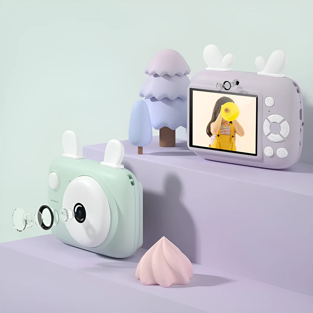 Macaron Mini SLR kids camera in green, pink, purple, or red, showing dual lenses and a 2.4-inch screen.