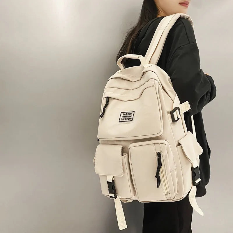 Black and white soft nylon student backpack showing external pockets and internal laptop compartment.