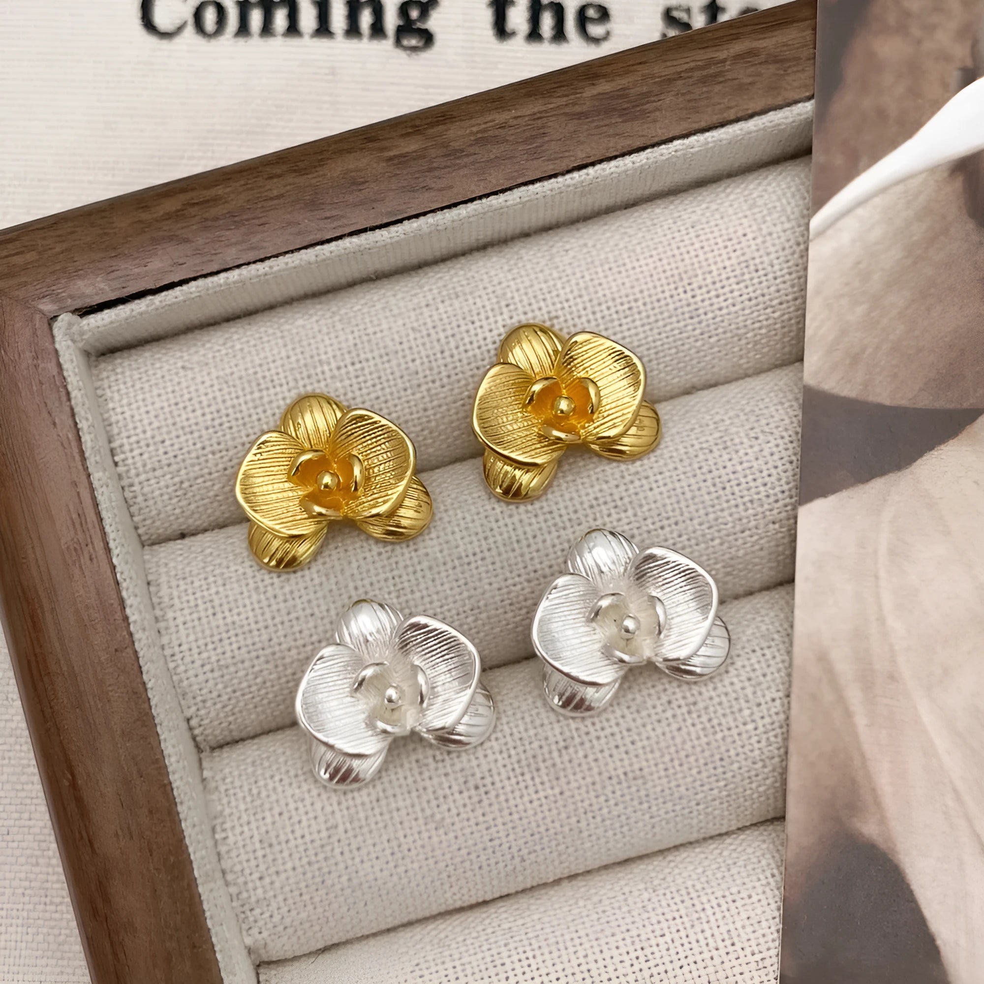 A pair of women's retro-style flower drop earrings with petal details in a gold or silver electroplated finish.