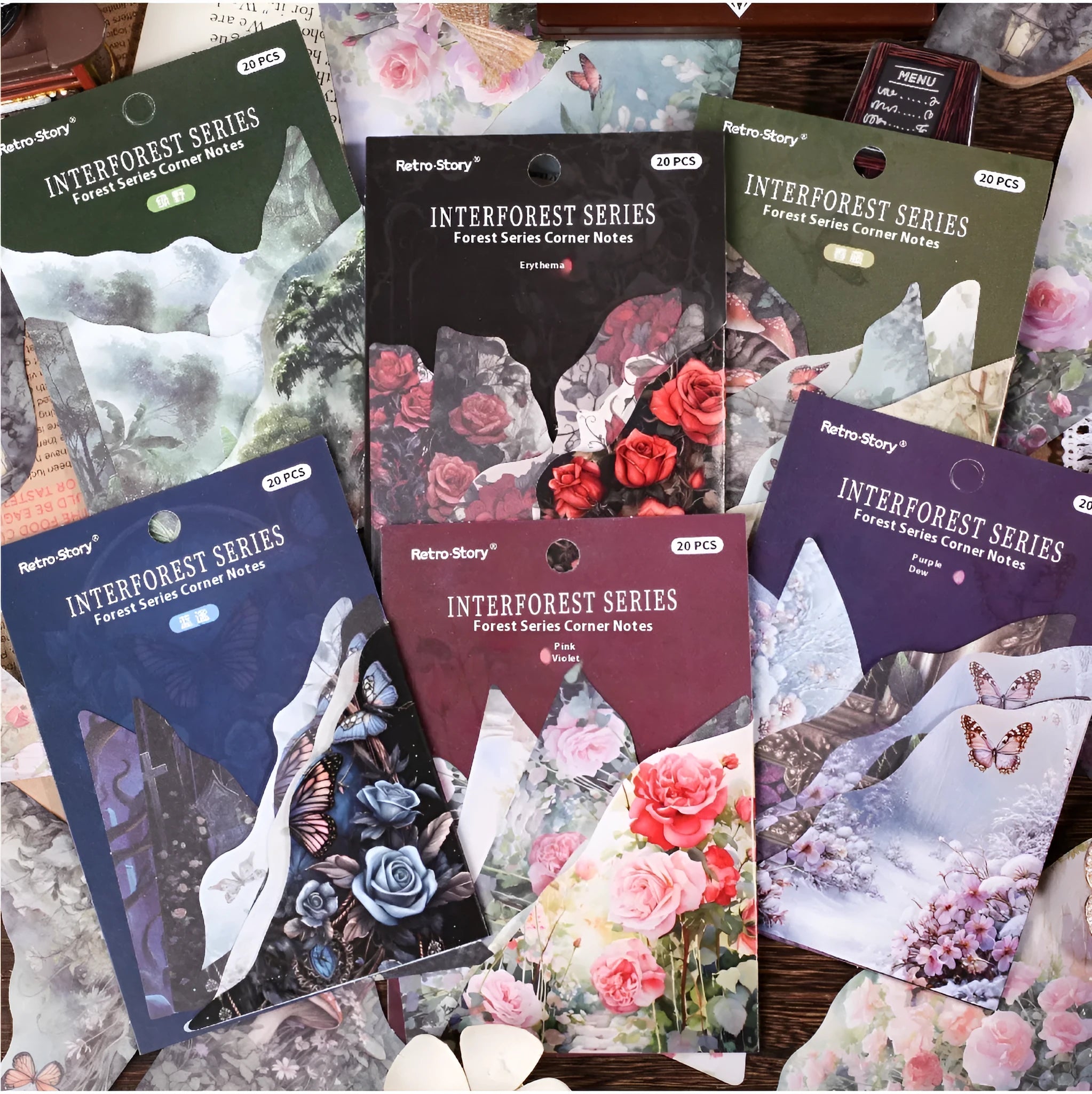 Decorative notebook set showing artistic covers in spring vine, pink plum, red rose, blue, green field, and purple dew colours.