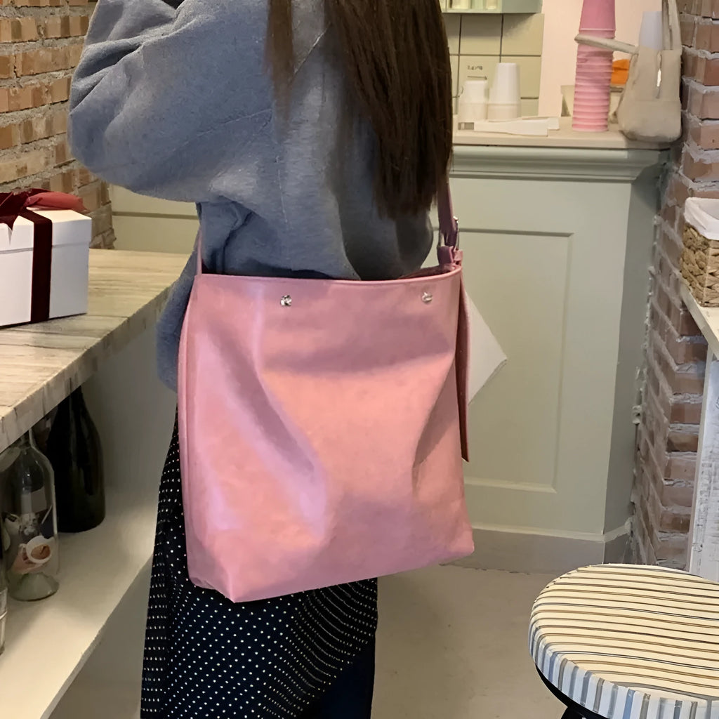 Corduroy single-shoulder commuter bag in pink with rectangular shape showing textured fabric