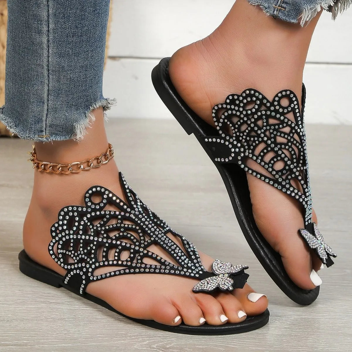 Black women's slip-on sandals with rhinestone detail and a flip-toe opening.