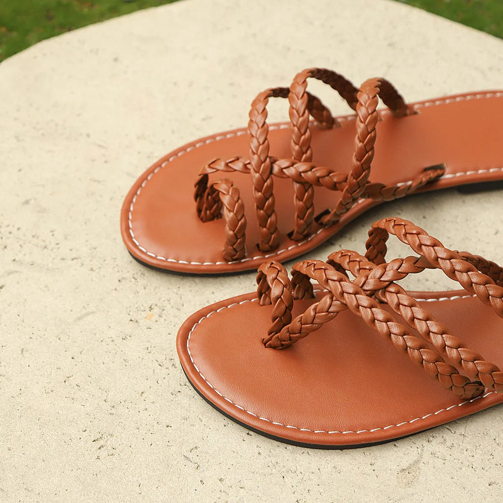 Womens woven Roman sandals with clip toe and flat rubber sole, in white, black, or brown.
