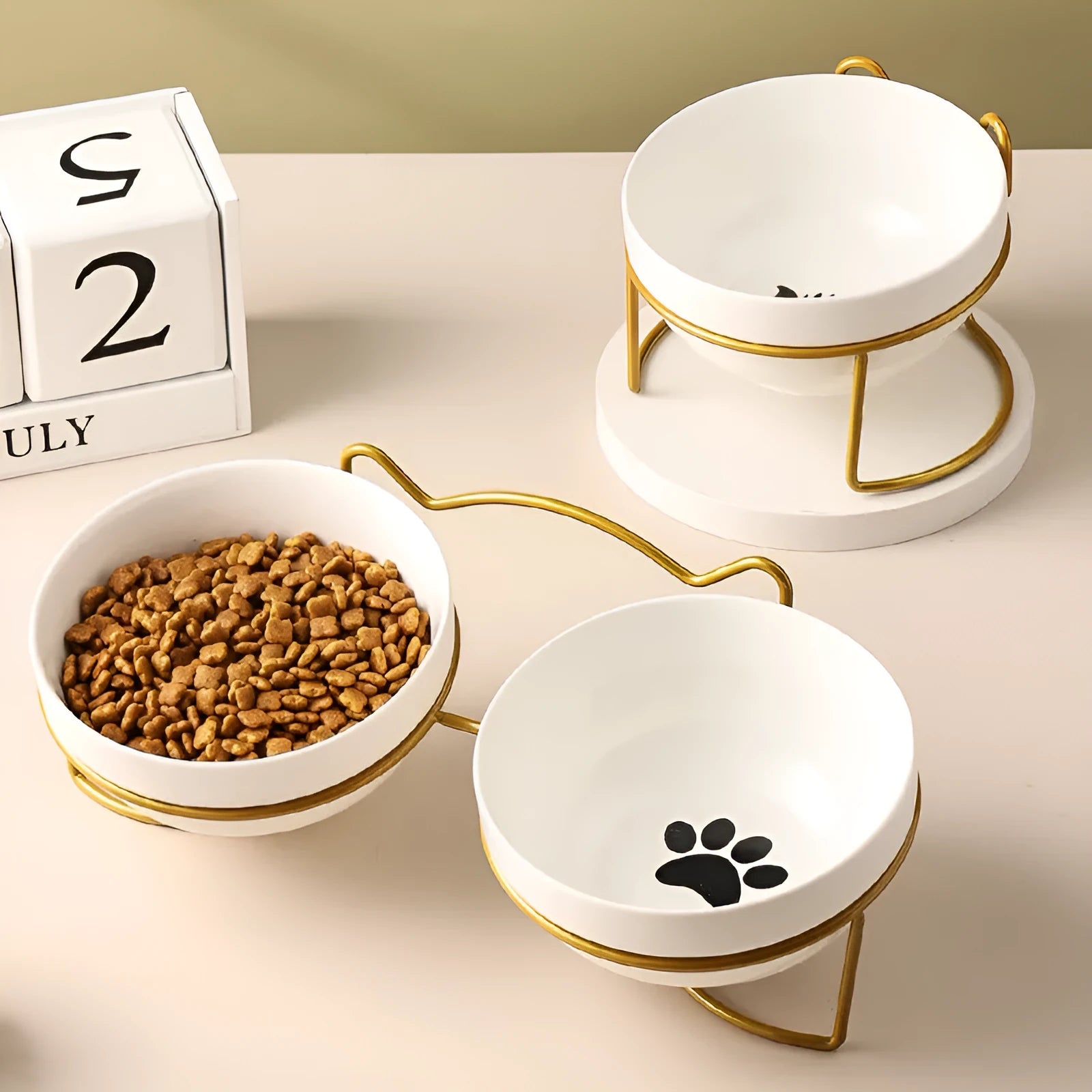White ceramic cat bowl with decorative footprints in black iron frame with cat ear detailing