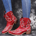 Blue women's cowboy boots with embroidered detail, a low wedge heel, and a pointed toe.