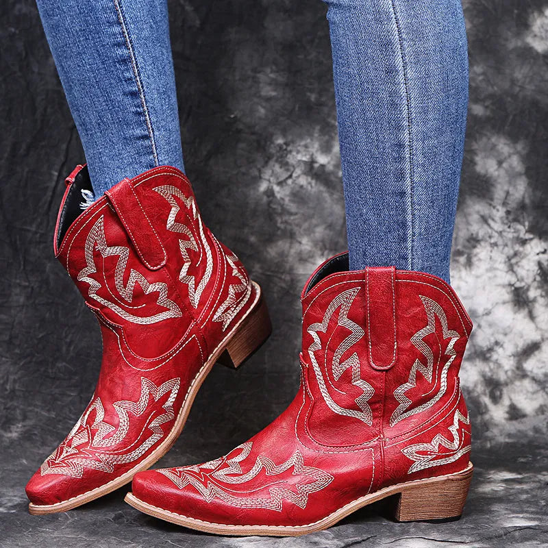 Blue women's cowboy boots with embroidered detail, a low wedge heel, and a pointed toe.