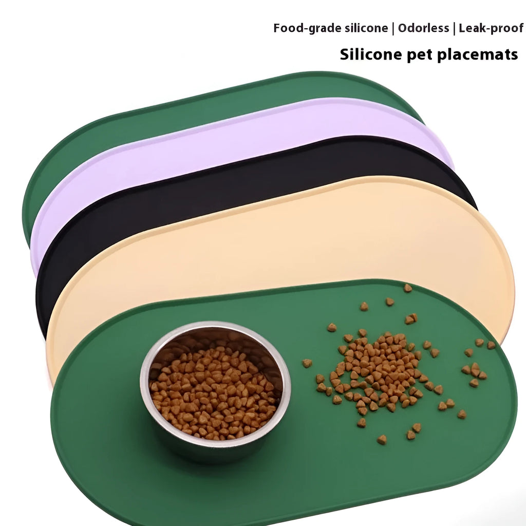 Green silicone placemat for cat bowls on a wooden floor.