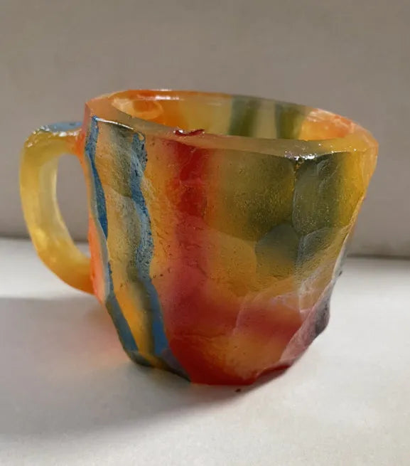Purple and blue resin coffee mug with crystal texture and handle on wooden table