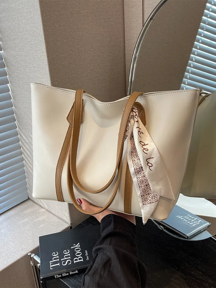 Soft women's crossbody tote bag in bucket silhouette showing sandwich pocket detail and shoulder strap